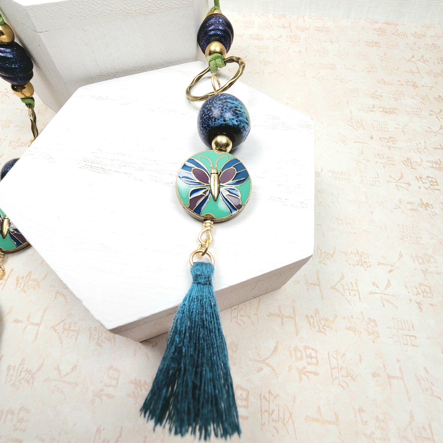 Boho Butterfly Necklace – Handmade Jewelry with Brass Coin Beads, Blue Ceramic, Teal Tassel & Green Faux Suede Cord